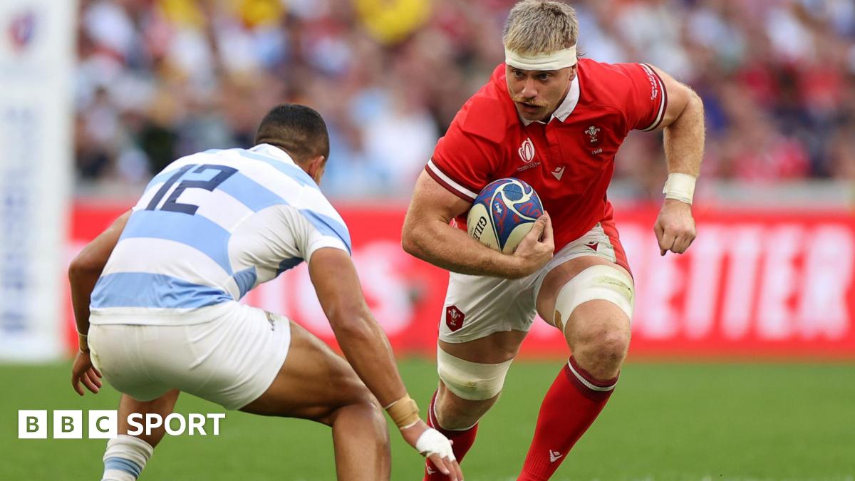 Wales number eight Aaron Wainwright is challenged by an Argentina player as he runs with ball 