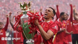Trent Alexander-Arnold lifts the Premier League trophy on his final Liverpool appearance at Anfield.