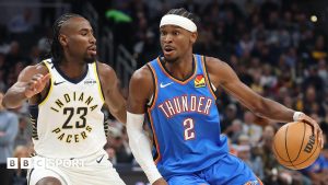 Shai Gilgeous-Alexander #2 of the Oklahoma City Thunder dribbles the ball while defended by Aaron Nesmith #23 of the Indiana Pacers