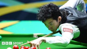 Wu Yize playing a shot