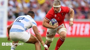 Wales number eight Aaron Wainwright is challenged by an Argentina player as he runs with ball 